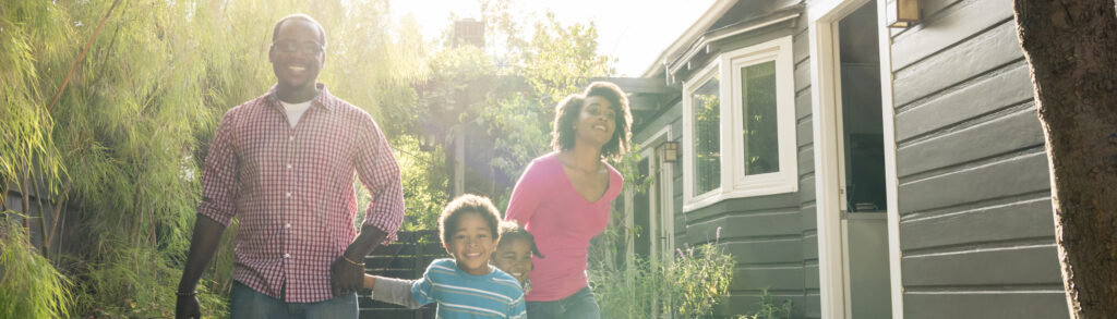 Family outside their home on a sunny day