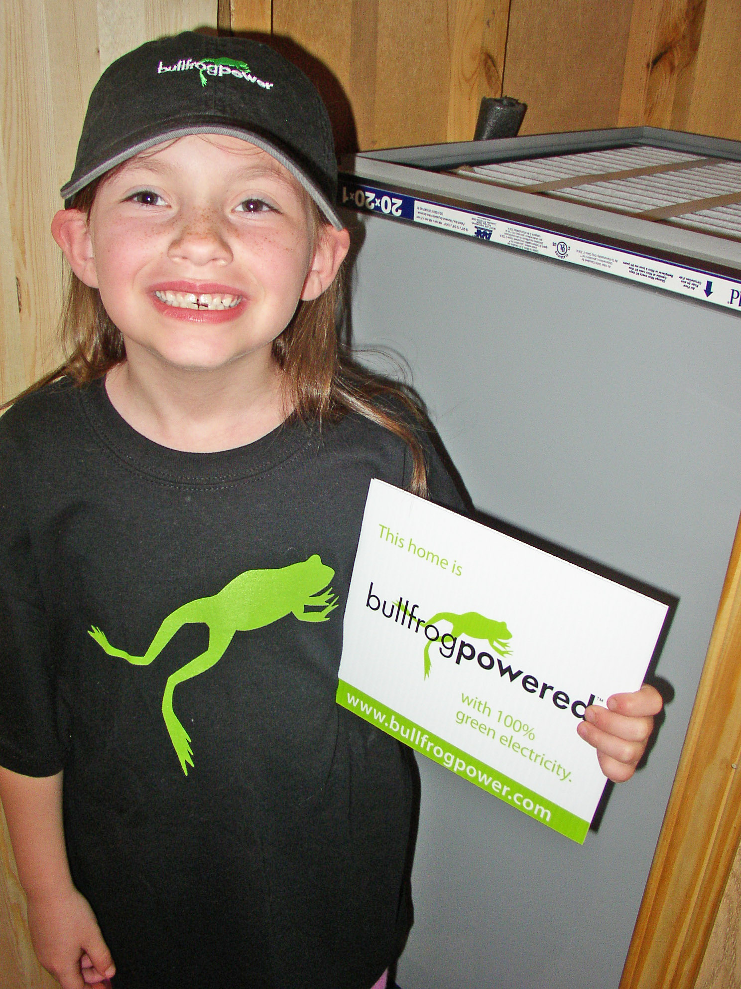 Customer's daughter holding Bullfrog Power lawn sign